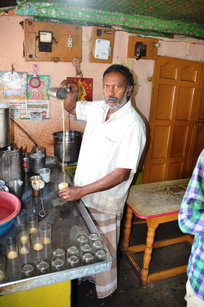 Homem a servir Massala Tea num café na fronteira entre Tamil Nadu e Kerala